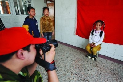 《扬子晚报》:南艺志愿者为民工孩子拍证件照